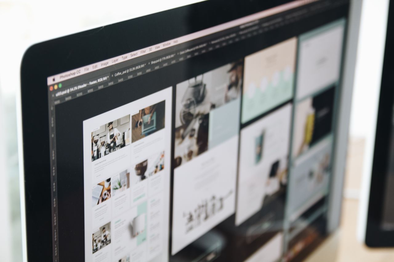 Moderní počítačová obrazovka s ukázkou webdesignové práce a kreativních vizuálů v pracovním prostředí.